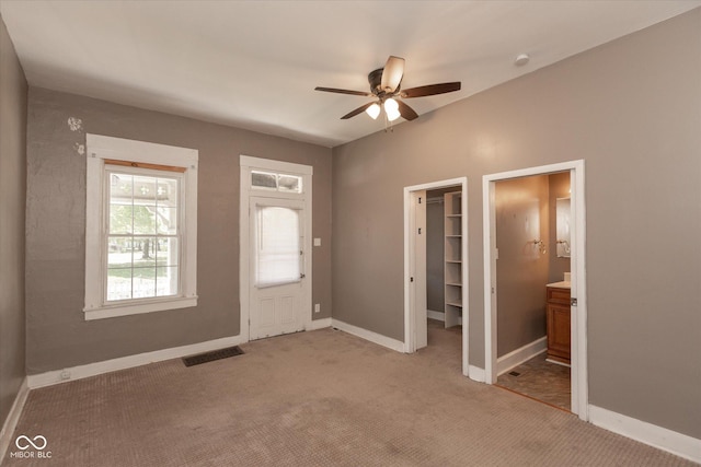 carpeted foyer entrance featuring visible vents, ceiling fan, and baseboards