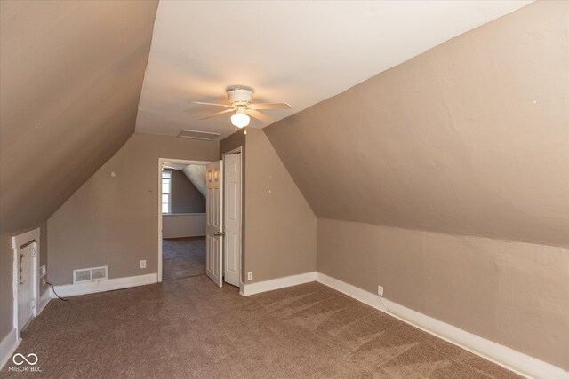 additional living space with carpet flooring, baseboards, visible vents, and vaulted ceiling