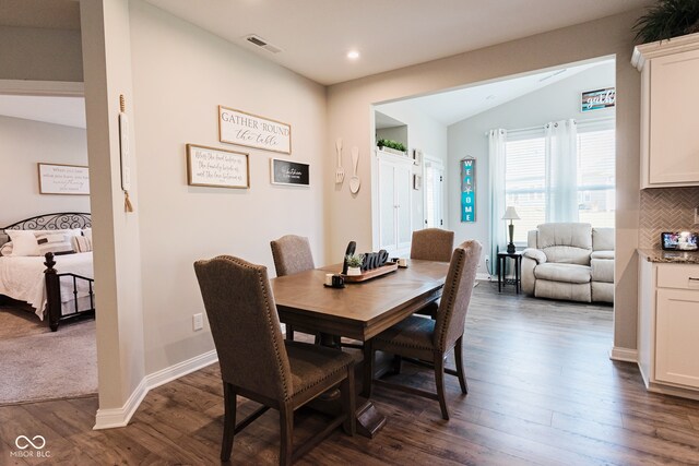 dining room with vaulted ceiling and dark hardwood / wood-style floors