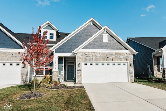 craftsman inspired home featuring a garage and a front lawn