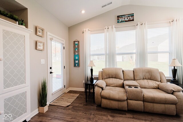 living room with a healthy amount of sunlight, lofted ceiling, and dark hardwood / wood-style flooring