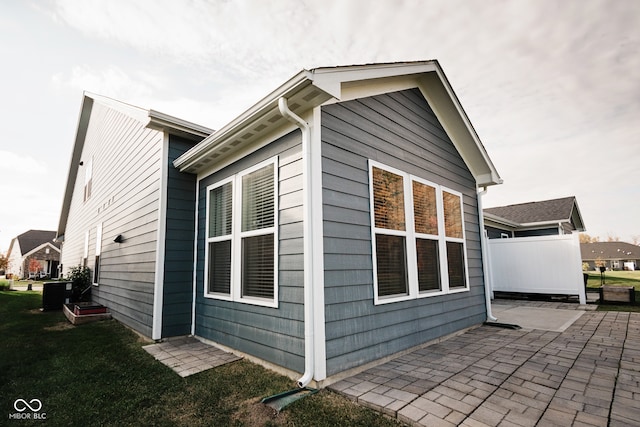 view of side of property featuring a patio and cooling unit