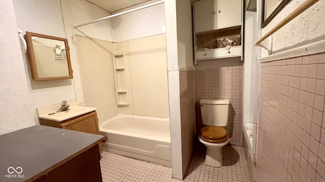 full bathroom featuring shower / bath combination, tile walls, vanity, tile patterned floors, and toilet