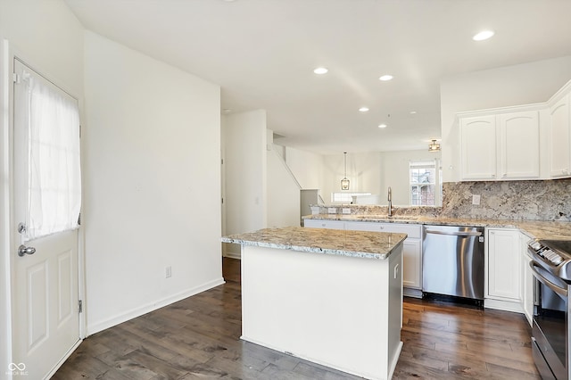 kitchen featuring dark hardwood / wood-style floors, a center island, stainless steel appliances, and white cabinetry