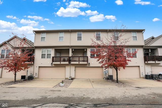 view of property featuring a balcony, a garage, and central AC unit