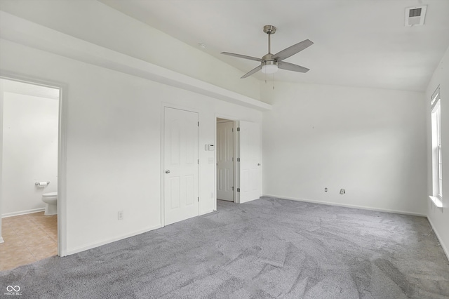 spare room featuring ceiling fan, light colored carpet, and vaulted ceiling