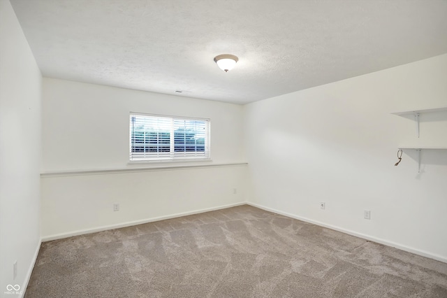 spare room featuring a textured ceiling and carpet floors