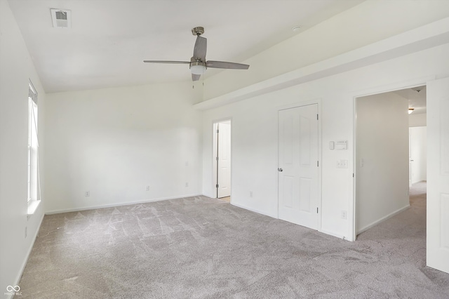 unfurnished bedroom with light colored carpet, vaulted ceiling, and ceiling fan