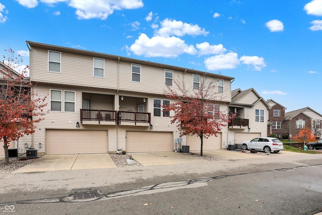 view of front of house with a balcony, central AC unit, and a garage