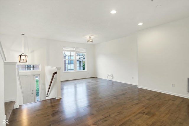 entrance foyer featuring an inviting chandelier and dark hardwood / wood-style flooring