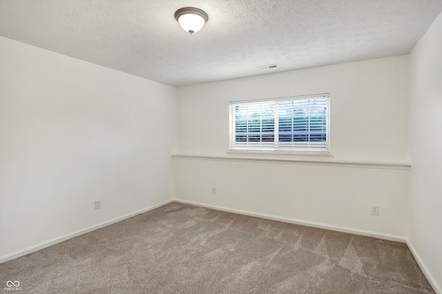 carpeted empty room with a textured ceiling