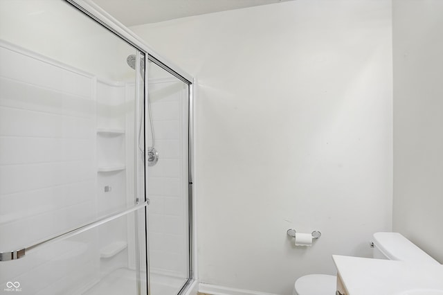 bathroom with vanity, a shower with shower door, and toilet