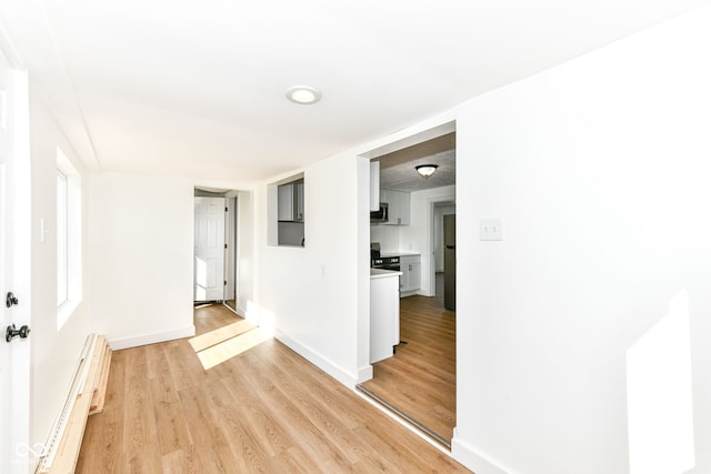 corridor featuring a baseboard radiator and light wood-type flooring