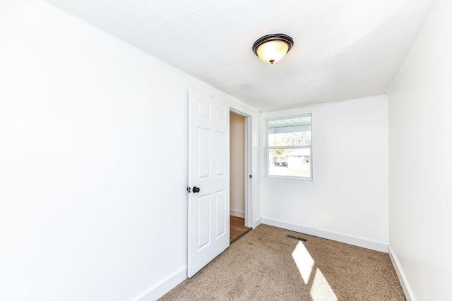 unfurnished room with a textured ceiling and carpet floors