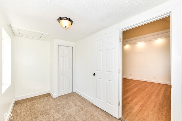 hall featuring light hardwood / wood-style flooring and a textured ceiling