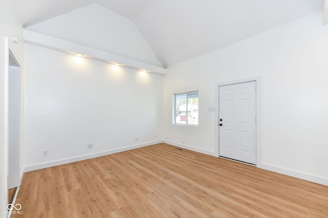 unfurnished room with high vaulted ceiling and light hardwood / wood-style floors