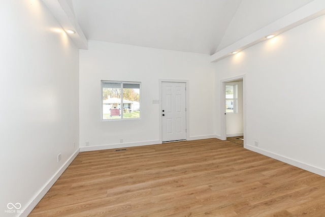 unfurnished room with light hardwood / wood-style floors and vaulted ceiling