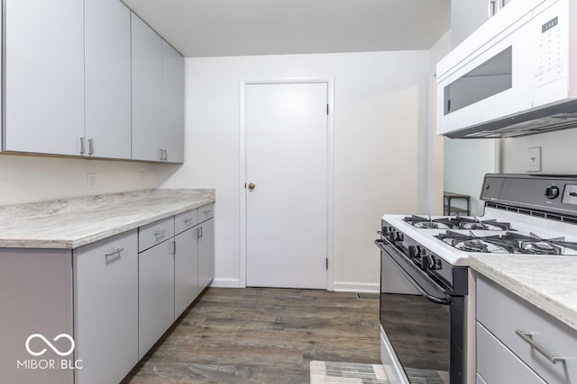 kitchen featuring white appliances and dark wood-type flooring