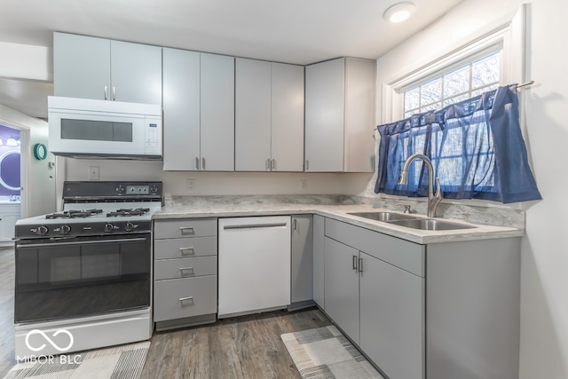 kitchen featuring gray cabinets, sink, dark wood-type flooring, and white appliances