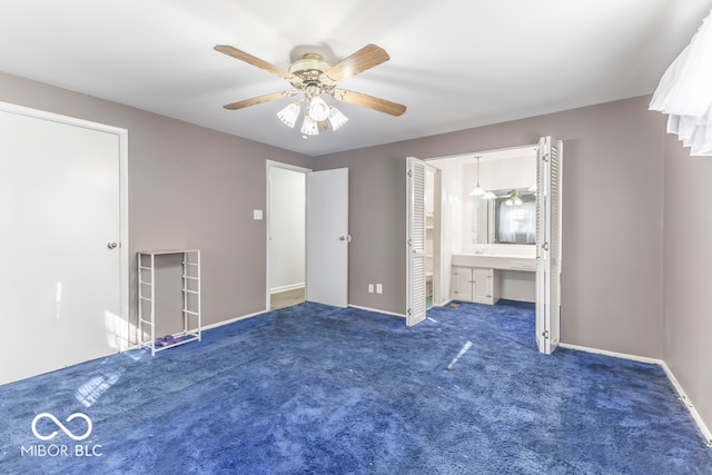 unfurnished bedroom featuring dark colored carpet, connected bathroom, and ceiling fan