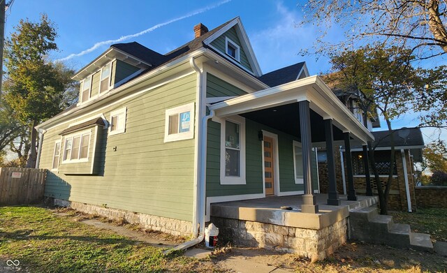 view of side of property featuring covered porch