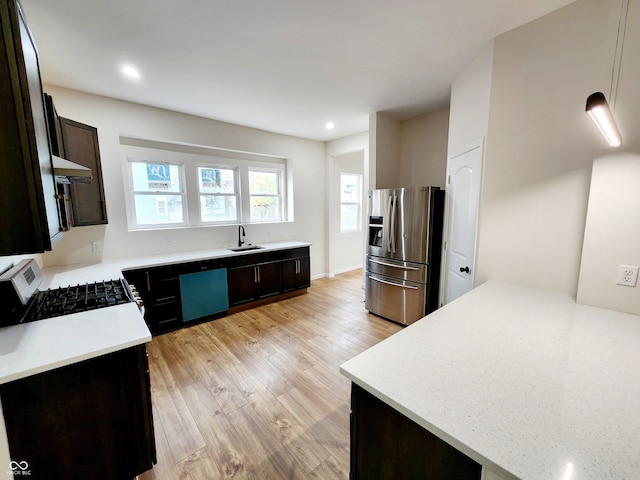 kitchen with sink, stainless steel refrigerator with ice dispenser, light hardwood / wood-style floors, range hood, and range with gas stovetop