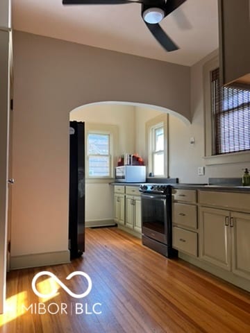 kitchen with black fridge, ceiling fan, light hardwood / wood-style floors, and electric range