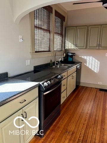 kitchen featuring sink, electric range, dark hardwood / wood-style flooring, and cream cabinetry