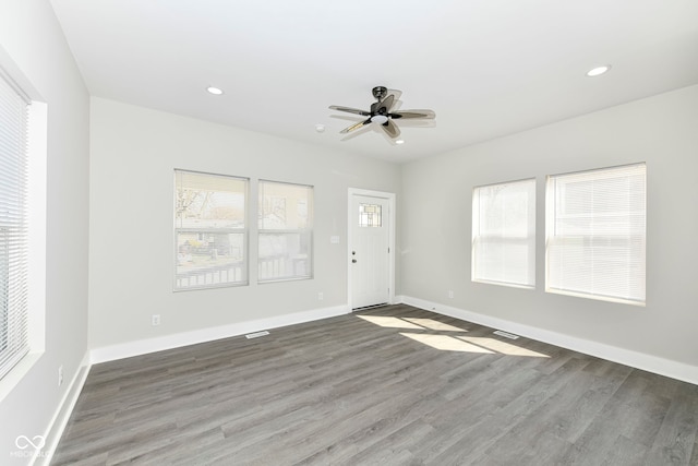 spare room with ceiling fan, wood-type flooring, and plenty of natural light