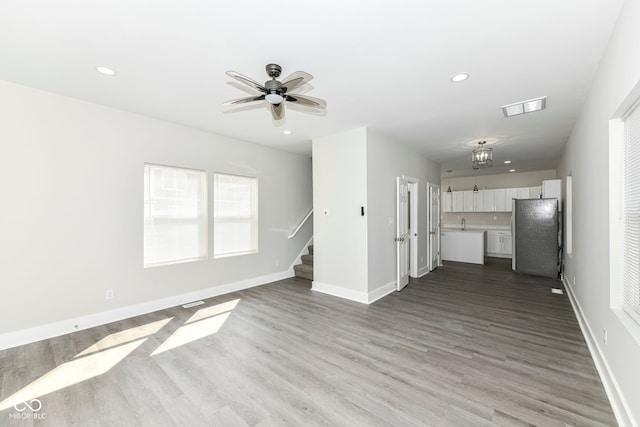 unfurnished living room featuring light hardwood / wood-style flooring and ceiling fan