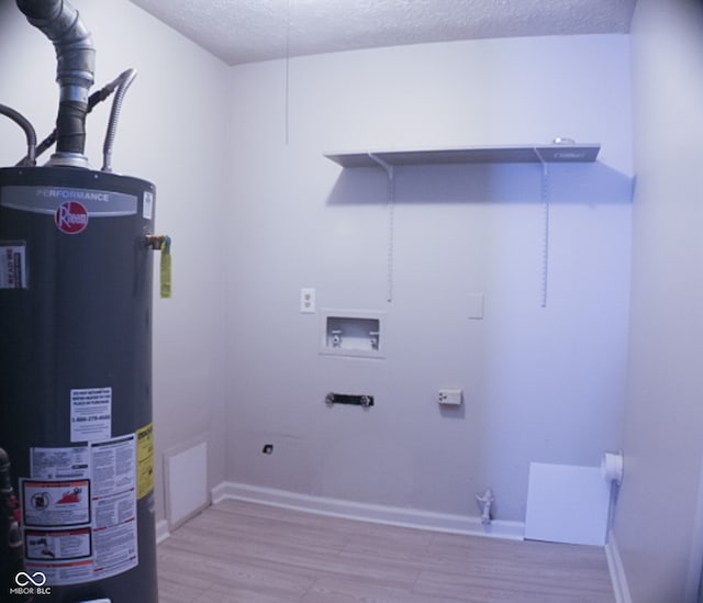 laundry area with hookup for a washing machine, a textured ceiling, water heater, light hardwood / wood-style floors, and electric dryer hookup