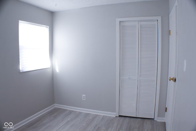 unfurnished bedroom featuring a closet and light hardwood / wood-style flooring