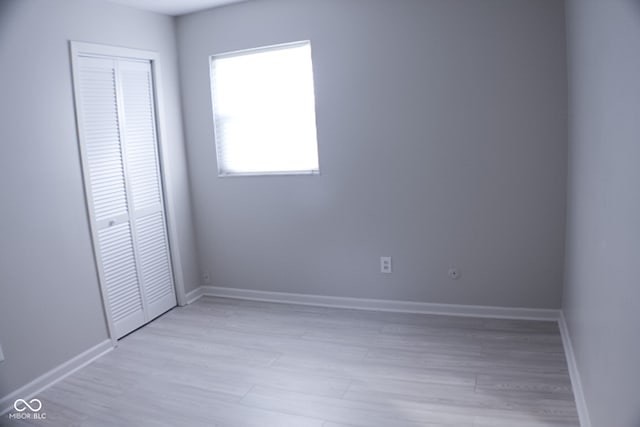 unfurnished bedroom featuring light hardwood / wood-style floors and a closet