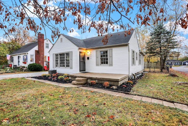 view of front of house with central air condition unit and a front lawn