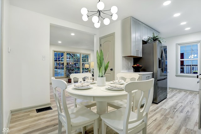 dining area featuring light hardwood / wood-style floors and a notable chandelier