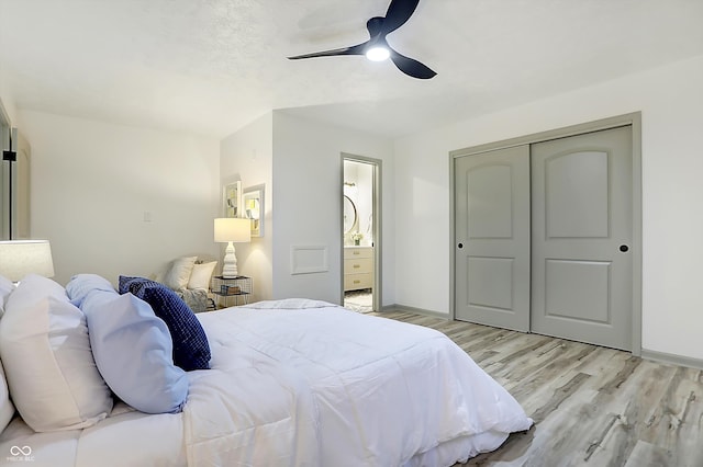 bedroom with light wood-type flooring, connected bathroom, ceiling fan, and a closet