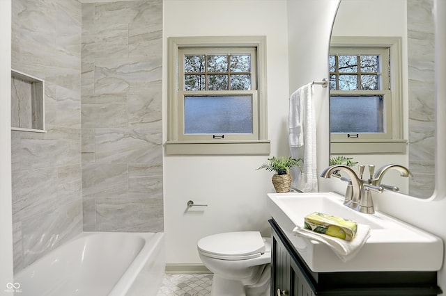 full bathroom with a wealth of natural light, vanity, tiled shower / bath combo, and toilet