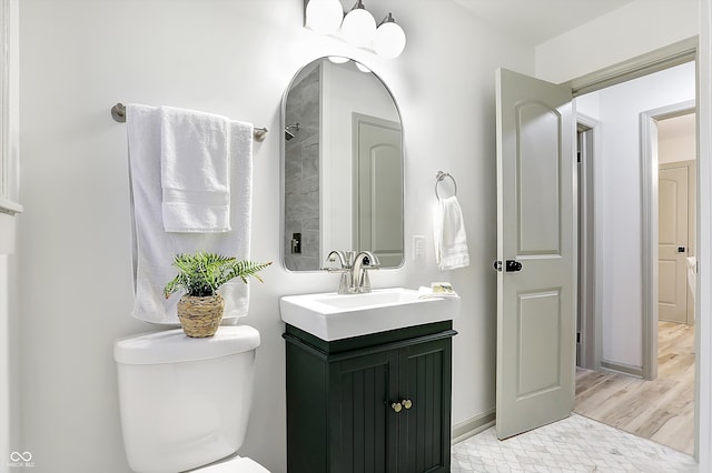 bathroom with hardwood / wood-style flooring, vanity, and toilet