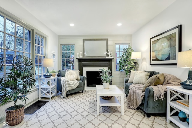 living room featuring wood walls, a wealth of natural light, and carpet floors