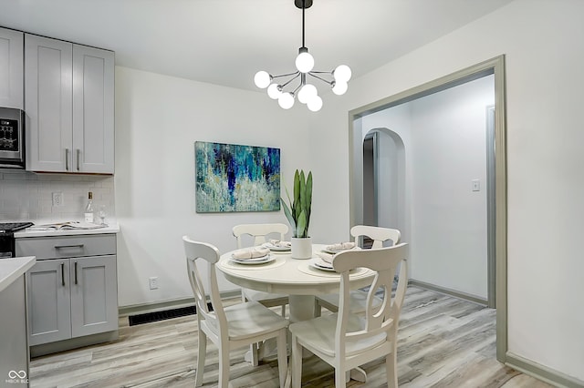 dining area featuring light hardwood / wood-style floors and a notable chandelier