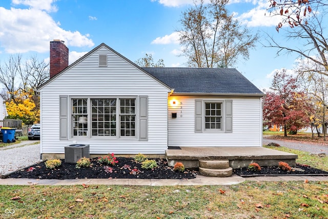 back of property with central AC unit and a yard