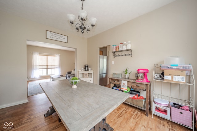 dining area featuring a chandelier and wood-type flooring