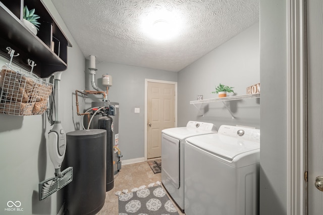 laundry area featuring light tile patterned floors, washing machine and dryer, a textured ceiling, and gas water heater