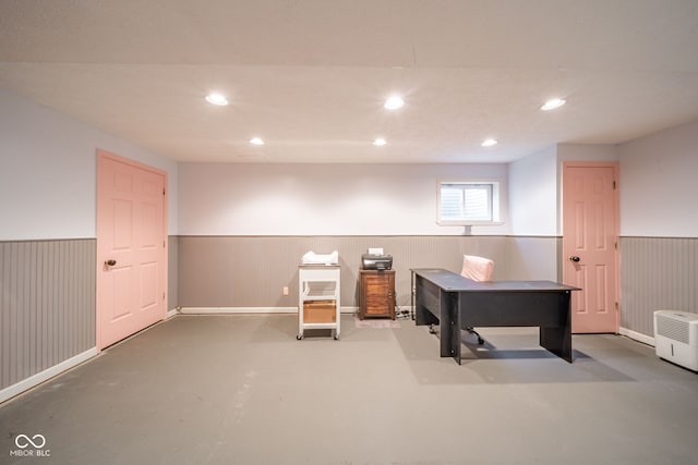 home office featuring concrete floors and wood walls