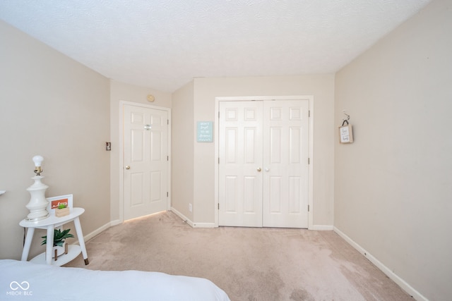 carpeted bedroom with a textured ceiling and a closet