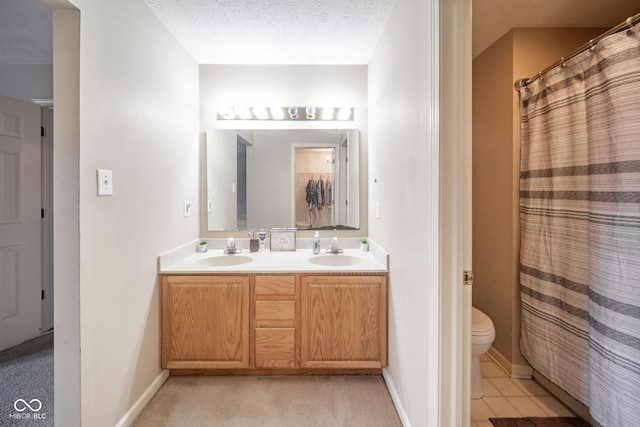 bathroom with tile patterned floors, toilet, vanity, a textured ceiling, and walk in shower