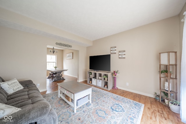 living room with hardwood / wood-style floors and a notable chandelier