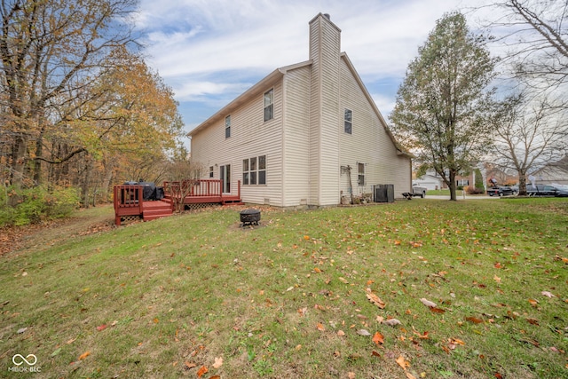 back of property featuring a yard, a deck, and central AC