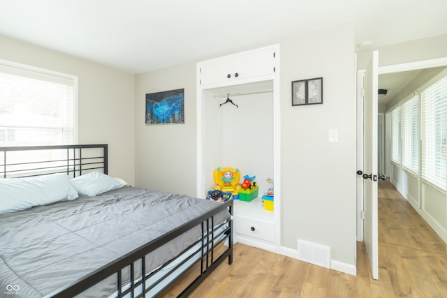 bedroom featuring light hardwood / wood-style flooring and multiple windows