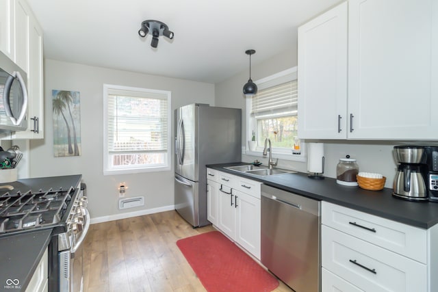 kitchen with white cabinetry, sink, light hardwood / wood-style flooring, and appliances with stainless steel finishes